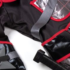 a black and red backpack sitting on top of a white table next to a pair of scissors