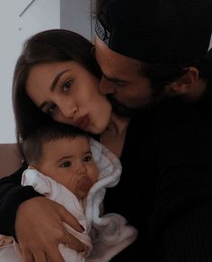 a man and woman holding a baby in their arms