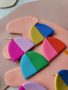 multicolored wooden earrings on pink background