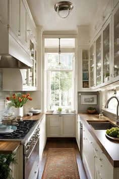 a kitchen filled with lots of white cabinets and counter top space next to a window