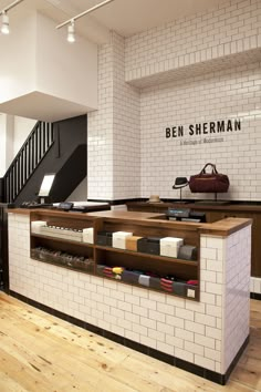 the interior of a shoe store with white brick walls and wooden flooring on one side