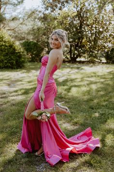 a beautiful woman in a pink dress posing for the camera with her legs spread out