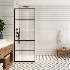 a bathroom with black and white tiles on the floor, shower stall and wooden bench