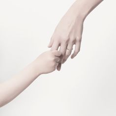 two people reaching out their hands to touch each other's hand, with one holding the other's hand