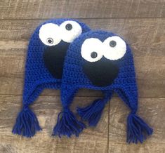 two crocheted hats with googly eyes and tassels on the sides