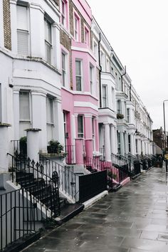 a row of houses painted pink and white on a rainy day in london, england