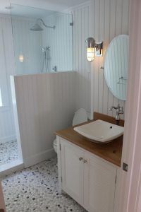 a bathroom with a sink, mirror and shower stall