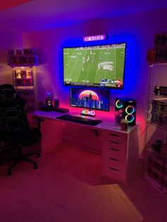 a room with a desk, chair and large screen television on it's wall