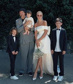 a family posing for a photo in front of some trees