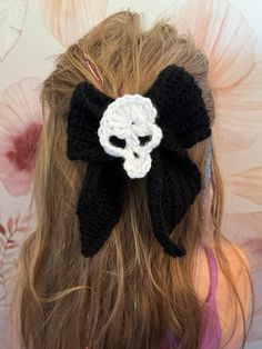 a close up of a woman's hair with a crocheted skull on it