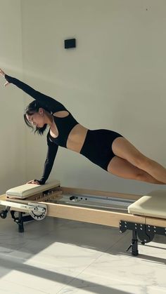 a woman is doing exercises on a piyor