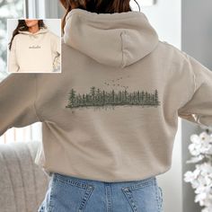 Stay cozy in our "Outsider" sweatshirt, featuring a graphic of a pine tree forest. This nature-inspired wilderness shirt is perfect for granola girls, nature lovers, and anyone who enjoys camping and hiking adventures. NOTE: ALL HOODIES ARE FRONT AND BACK. Prefer this design on a T-Shirt? Visit this link: https://bohemianbloomdesigns.etsy.com/listing/1764509611 Everything You Need to Know: 🧥 Sweatshirt Brand Gildan | Unisex Adult Sizing | 50% Cotton, 50% Polyester ⏳🚚 Production & Shipping All Graphic Hoodie Design Inspiration, Gifts For Outdoorsy Women, Nature Shirt Design, Nature Sweater, Granola Vibes, 2024 Clothes, Pine Tree Forest, Clothing Board, Hiking Adventures