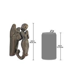 an angel figurine next to a metal can