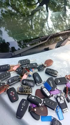 a bunch of car keys sitting on the hood of a car