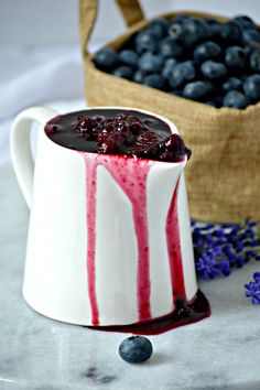 blueberries and cream in a white mug on a table