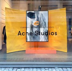 an acne studio window display with the words acne studios on it's side