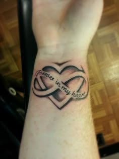 a person with a tattoo on their wrist that says peace is my heart and two intertwined hearts