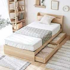 a bed sitting on top of a wooden platform next to a book shelf filled with books