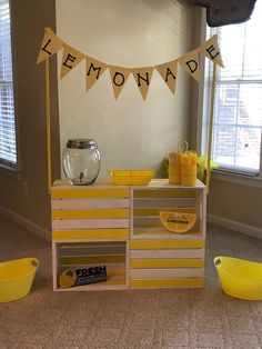 there is a lemonade stand in the room with yellow bowls and cups on it