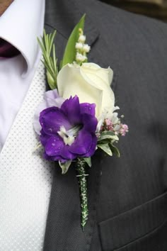 a boutonniere with purple and white flowers