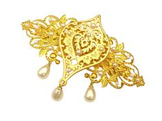 This large, unique hair clip is a beautiful accessory for the golden bride or for other festive occasions. The hair accessory is made of gold-colored metal. The drop ornament in the middle is plated with real gold. The hair clip is also decorated with white half pearls. Three white drop pendants are attached to the bottom of the hair clip. The hair clip, including the drop pendants, measures 7 L x 9.5 W cm. Gold Hair Clip, Unique Hair Clip, Bridal Hair Accessory, Gold Hair Clips, Unique Hair, Pearl Hair, Bridal Hair Accessories, Drop Pendant, Gold Pearl