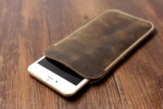 a cell phone in a leather case on a wooden table