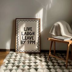 a black and white poster sitting on top of a wooden chair next to a wall