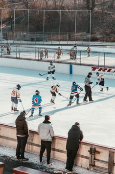 an ice hockey game is being played on the rink with people standing around and watching