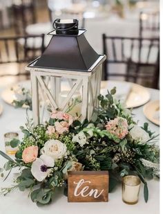 a table topped with a lantern and flowers