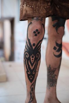 a man with tattoos on his legs and leg