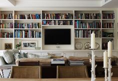 a living room filled with furniture and a flat screen tv mounted on a wall above a fireplace