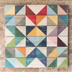 a colorful wooden wall hanging on a brick wall