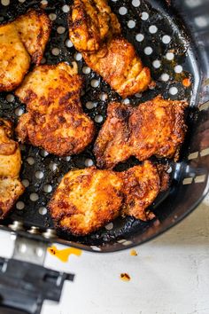 chicken is cooking in a frying pan on the stove top, with other ingredients nearby