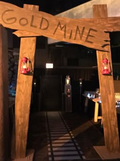 a wooden sign that says gold mine with two red lanterns hanging from it's sides