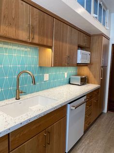 a kitchen with wooden cabinets and blue tile backsplash, white counter tops, and stainless steel appliances