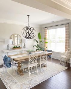 a dining room table with chairs and a rug on the floor in front of it