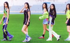 the girls are walking around on the field in their sport clothes and shoes, one is carrying a backpack