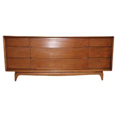 a wooden dresser sitting on top of a white wall