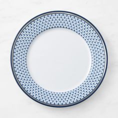 a blue and white plate sitting on top of a marble countertop next to a knife