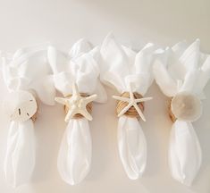 three napkins with starfish and seashell on them are lined up next to each other