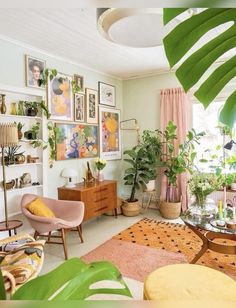 a living room filled with lots of plants and furniture