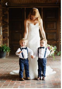 a woman and two young boys standing in front of a building