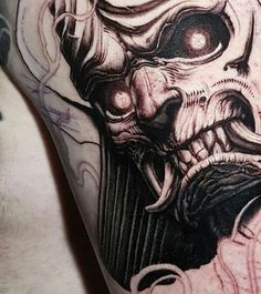 a close up of a man's arm with a tattoo on it and an image of a demon