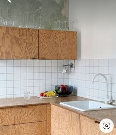 a kitchen with wooden cabinets and white tile backsplash, sink and dishwasher