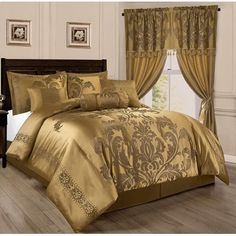 a bed in a bedroom with gold comforter and curtains