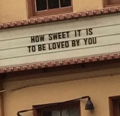 a sign on the side of a building that says how sweet it is to be loved by you