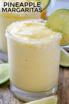 two margaritas sitting on top of a wooden table