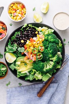 a bowl filled with broccoli, black beans, corn and avocado