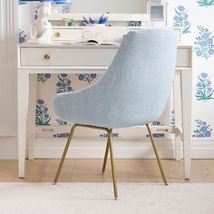 a blue chair sitting in front of a desk with a mirror on top of it