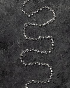 a chain with a cross on it sitting on top of a stone floor next to a black and white photo